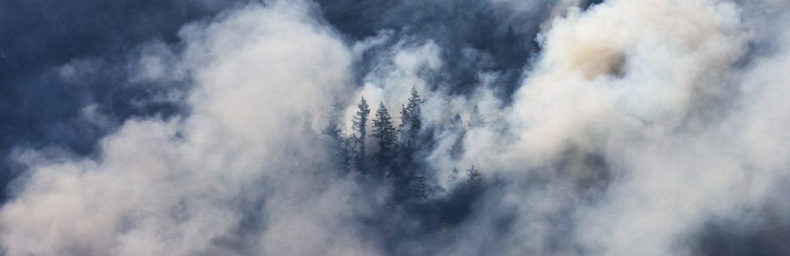 BC Forest Fire and Smoke over the mountain near Hope during a hot sunny summer day. British Columbia, Canada. Wildfire natural disaster